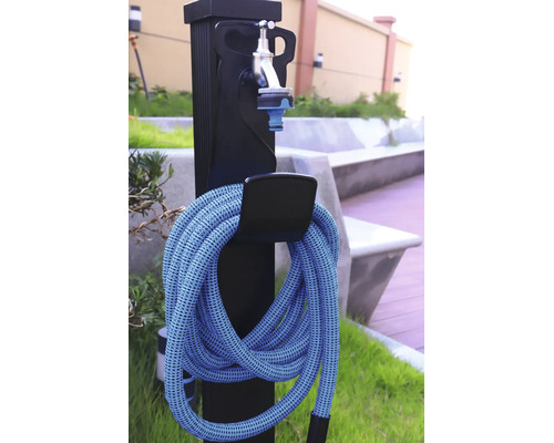 Borne fontaine de jardin avec tuyau d'arrosage flexible et robinet sur une colonne noire.
