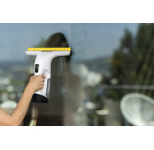 Nettoyeur de vitres sans fil utilisé pour nettoyer une vitre.