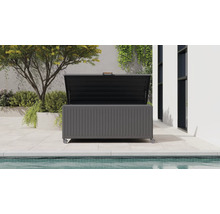 Coffre de jardin moderne en métal gris foncé avec roulettes et couvercle ouvert, sur une terrasse à côté d'une piscine et de plantes.