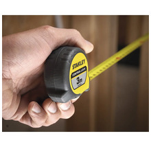 Mètre ruban Stanley Control-Lock de 3 mètres, tenu dans une main.