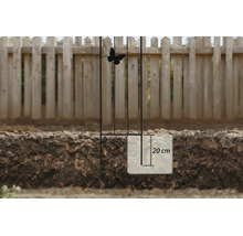 Treillage en métal avec décoration papillon, illustration de la profondeur d'encastrement de 20 centimètres dans le sol devant une clôture.
