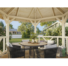 Pavillon de jardin moderne en bois clair avec table ronde et chaises tressées sombres dans un jardin lumineux et soigné.