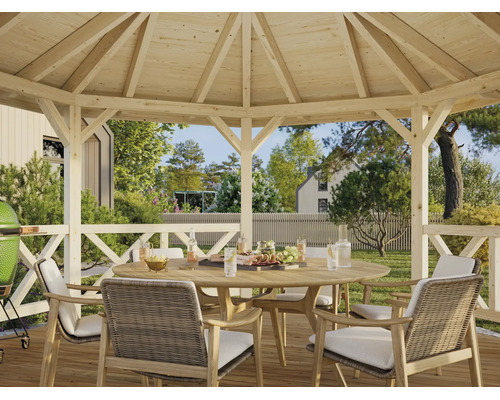 Holz-Gartenpavillon mit einer Sitzgruppe aus einem runden Holztisch und geflochtenen Stühlen in einem hellen, weitläufigen Garten.