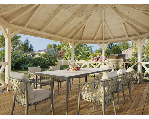 Offener Holzpavillon mit Gartentisch und geflochtenen Sesseln auf einer Holzterrasse in einem begrünten Garten.