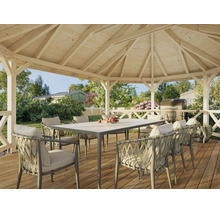 Pavillon de jardin ouvert en bois avec table et fauteuils tressés sur une terrasse en bois dans un jardin verdoyant.