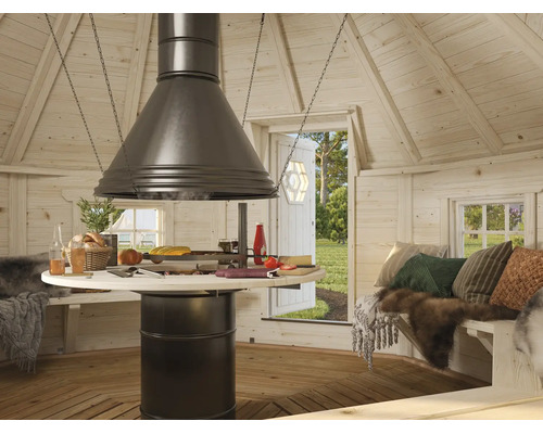 Innenansicht einer Grillkota aus hellem Holz mit zentralem Grill, Dunstabzugshaube, rundem Tisch, Sitzbänken und Blick ins Freie.