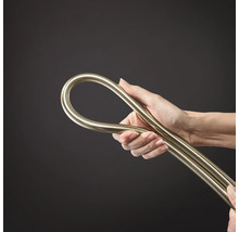 Hand hält einen flexiblen metallischen Installationsschlauch oder ein biegsames Metallrohr.