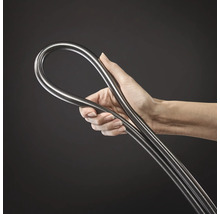 Hand hält einen flexiblen, metallischen Schlauch oder ein biegsames Rohr aus Edelstahl.