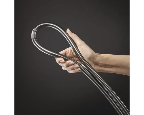 Hand hält einen flexiblen, metallischen Schlauch oder ein biegsames Rohr aus Edelstahl.