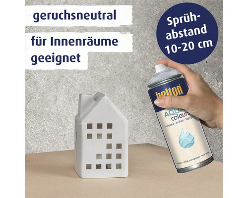 Hand sprüht Belton Aqua Colours Klarlack auf ein weißes Hausobjekt mit Informationen zu Geruchsneutralität und Sprühabstand.