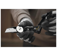 Personne avec des gants ouvrant un couteau pliant avec une lame interchangeable