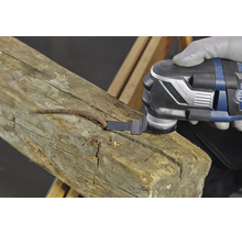 Un outil oscillant avec fixation StarlockPlus coupe un clou rouillé dans une poutre en bois.