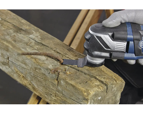 Un outil oscillant avec fixation StarlockPlus coupe un clou rouillé dans une poutre en bois.