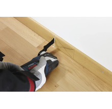 Un outil multifonction Bosch coupant une plinthe en bois avec des marques de mesure