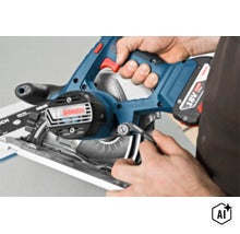 Eine Bosch Akku Handkreissäge mit 18 Volt Lithium Ionen Akku wird von einer Hand gehalten und auf einer Führungsschiene bedient. (Image AI modified or generated)