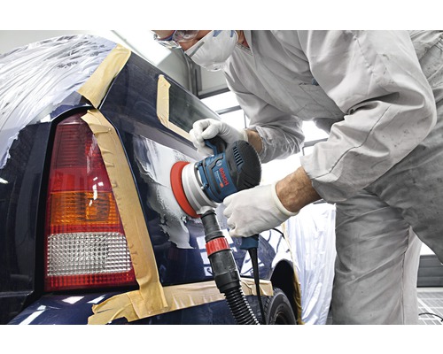 Employé travaillant sur une voiture avec une ponceuse