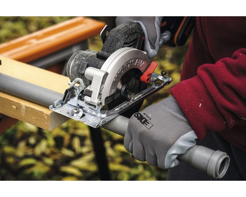 Scie circulaire portative coupant un tube en plastique sur un établi