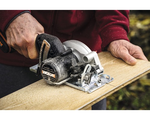 Une personne scie une planche de bois avec une scie circulaire portative de WORX.