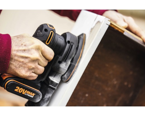 Eine Person verwendet einen Exzenterschleifer zum Abschleifen eines Holzstücks.