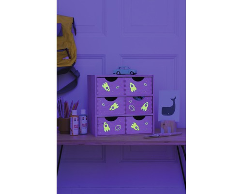 Étagère décorative en bois avec six tiroirs et motifs spatiaux sur une table avec du matériel de peinture