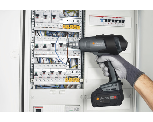 Ein Mann verwendet eine Steinel Heißluftpistole an einem Verteilerkasten