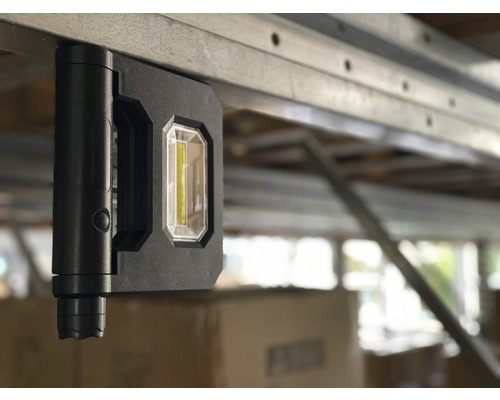 Lampe de travail noire avec aimant fixé sur du métal