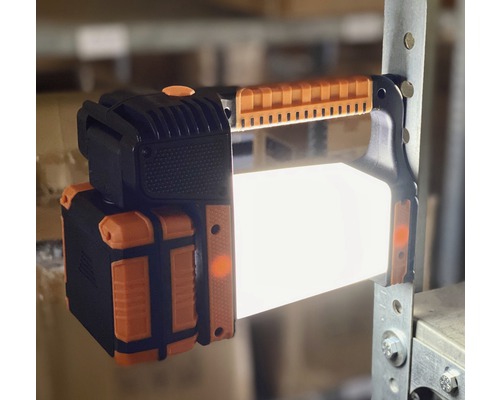 Lampe de travail LED avec poignée de transport fixée à une étagère.