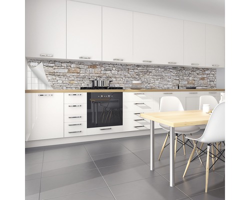 Scène de cuisine avec crédence aspect pierre, armoires blanches et table à manger