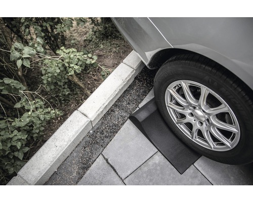 Auffahrkeil unter einem Reifen eines Autos auf Pflastersteinen
