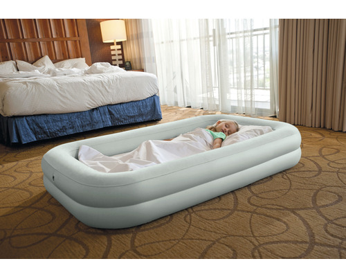 Aufblasbares Kinderbett mit schlafendem Kind im Zimmer.
