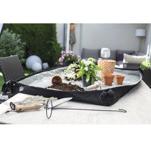 Scène de jardin avec accessoires de plantation, bac à plantes, terreau et plantes sur une table