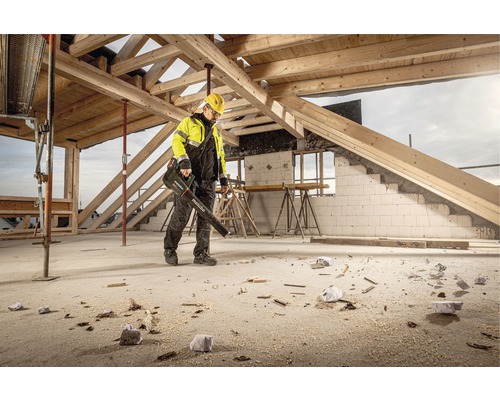 Un ouvrier utilise un souffleur de feuilles Metabo sur un chantier pour enlever la saleté et la sciure.