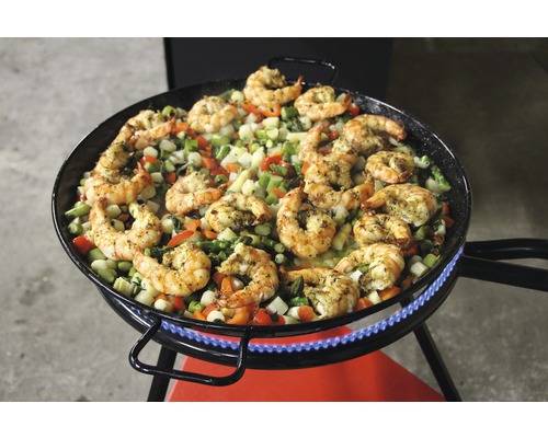 Paella mit Garnelen und Gemüse zubereitet auf einem Gasbrenner