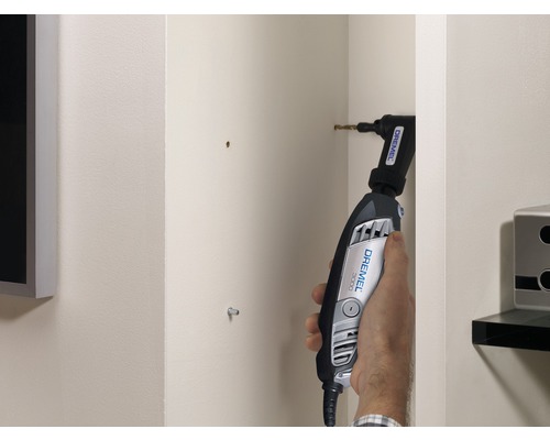 Une personne utilise un Dremel 3000 avec renvoi d''angle pour percer un mur.