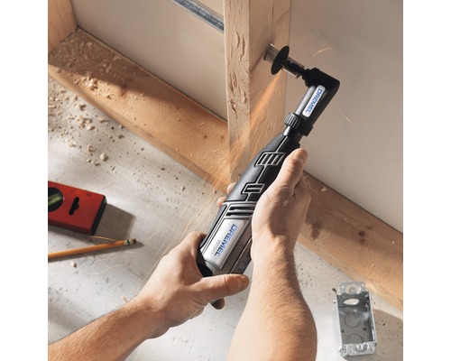 Une personne utilise un outil multifonction Dremel pour couper du bois.