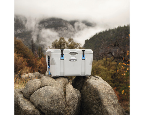 Kühlbox auf Felsen mit Berglandschaft im Hintergrund