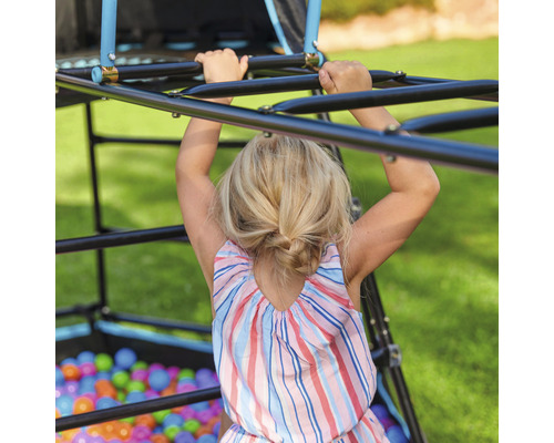 Enfant grimpant sur une aire de jeux d''escalade dans le jardin.
