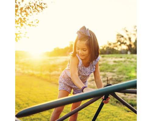 Fille jouant sur un portique d''escalade à l''extérieur