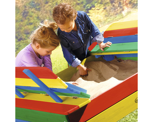 Deux enfants jouent dans un bac à sable coloré avec couvercle