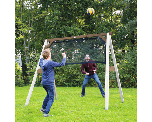 Dans le jardin, deux personnes jouent au volley-ball avec un filet de volley-ball.