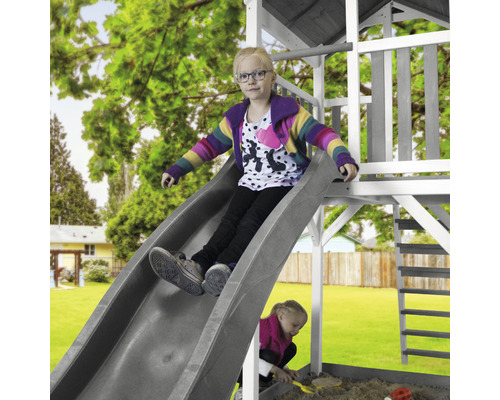 Enfant sur un toboggan d''une aire de jeux dans le jardin.