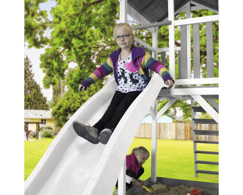 Une fille glisse sur un toboggan dans le jardin