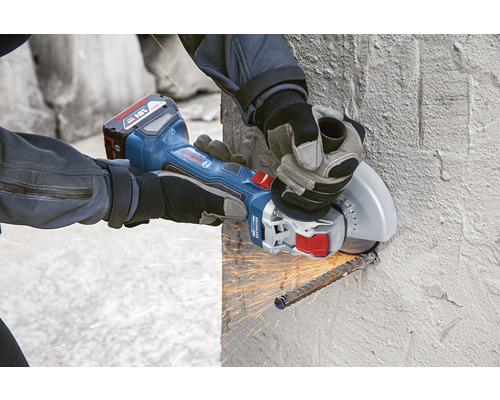 Akku-Winkelschleifer im Einsatz beim Schneiden von Bewehrungsstahl in einer Betonwand