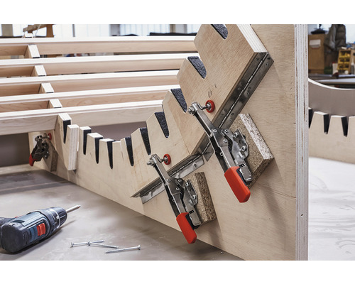 Construction en bois avec dispositif de serrage, visseuse sans fil et vis.