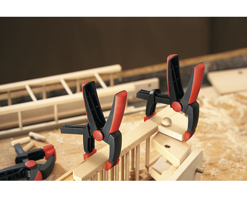 Pièce à travailler en bois avec des serre-joints à ressort sur un établi