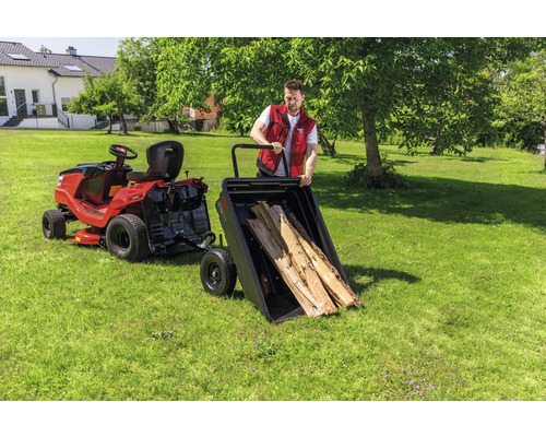 Tracteur de jardin avec remorque et bûches de bois dans le jardin
