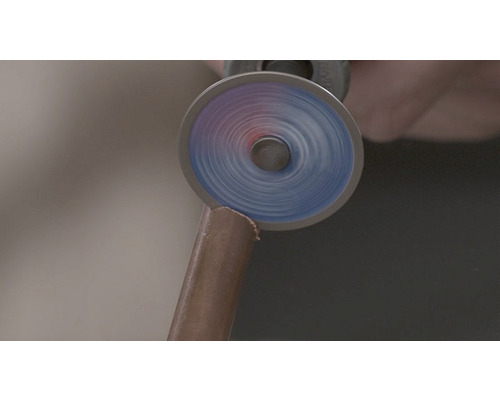 Outil rotatif coupant un tube de cuivre.