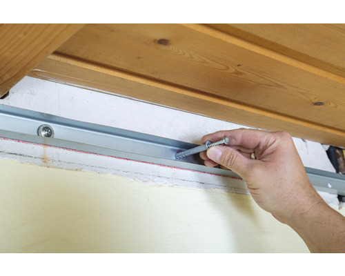 Installation d''un rail métallique avec cheville et vis sur un mur