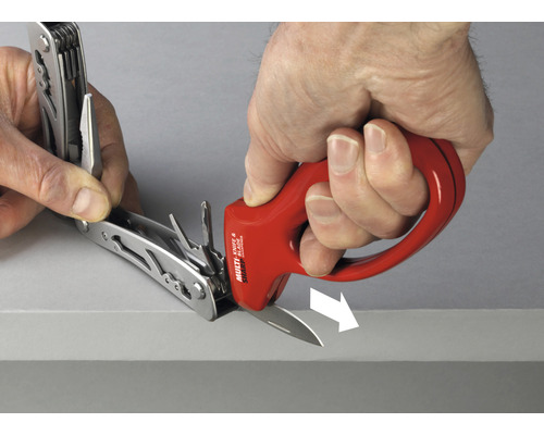 Une personne aiguise un couteau multifonction à l''aide d''un aiguiseur de couteaux.