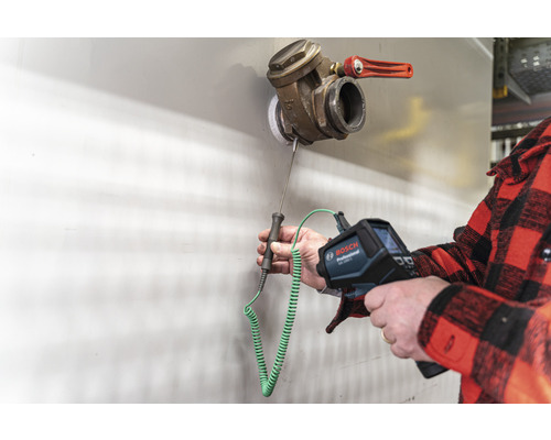 Une personne utilise une caméra thermique Bosch pour mesurer la température d'une vanne.